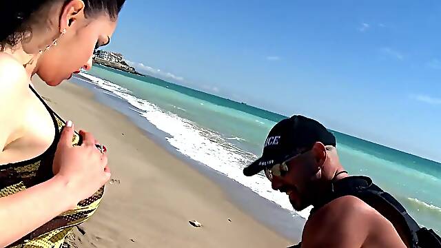 Hot MILF with big tits gets a helping hand from a police officer on the beach