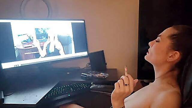 Brunette milf playing with her pussy while watching a smoking fetish video