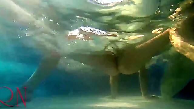 Elegant and supple chick, swimming underwater in the outdoor swimming pool. three two