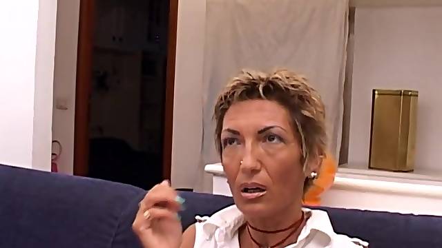 Aged blond woman with short hair is getting nailed on the bed, in the living room